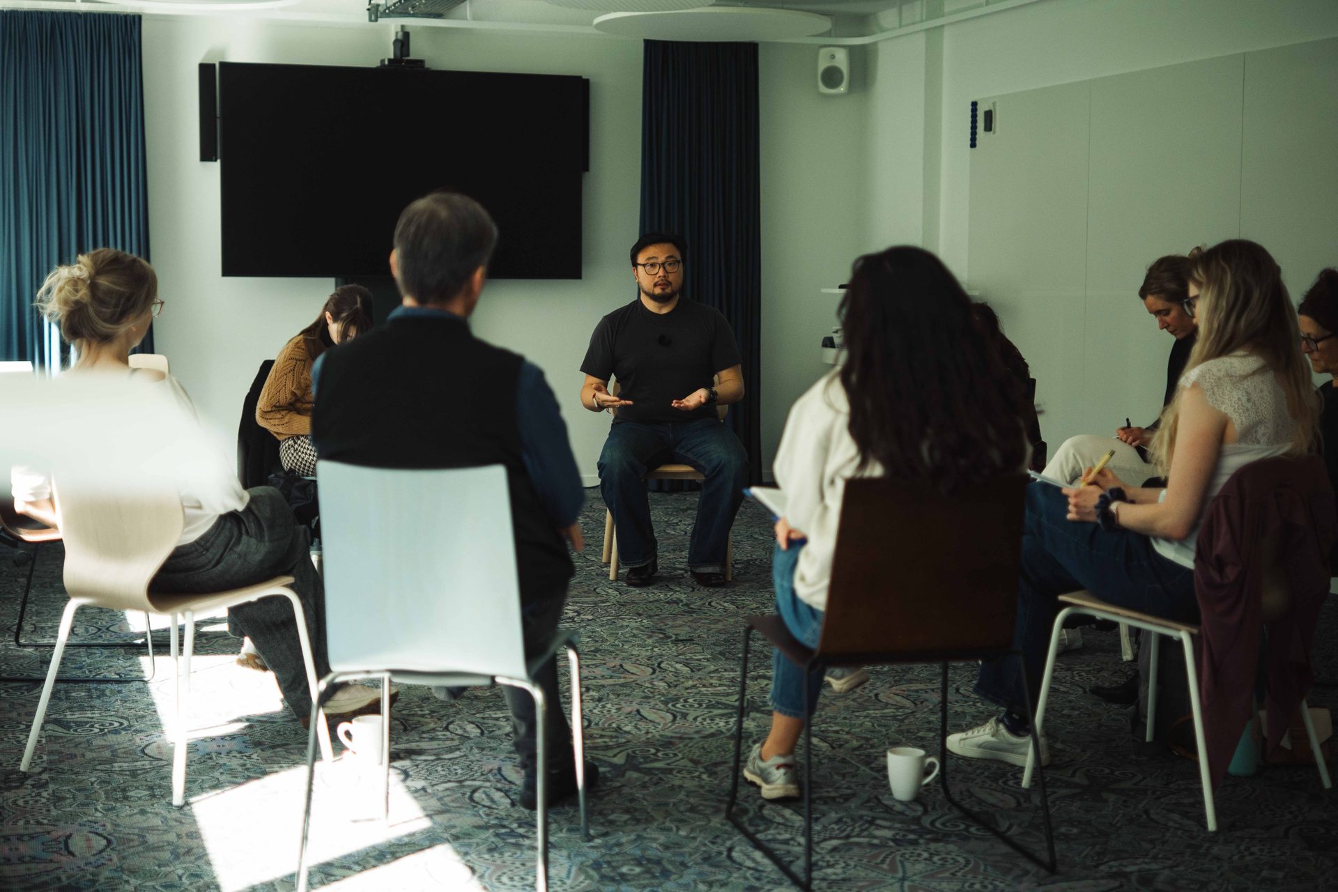 The group sitting in a circle during a class, listening to feedback.