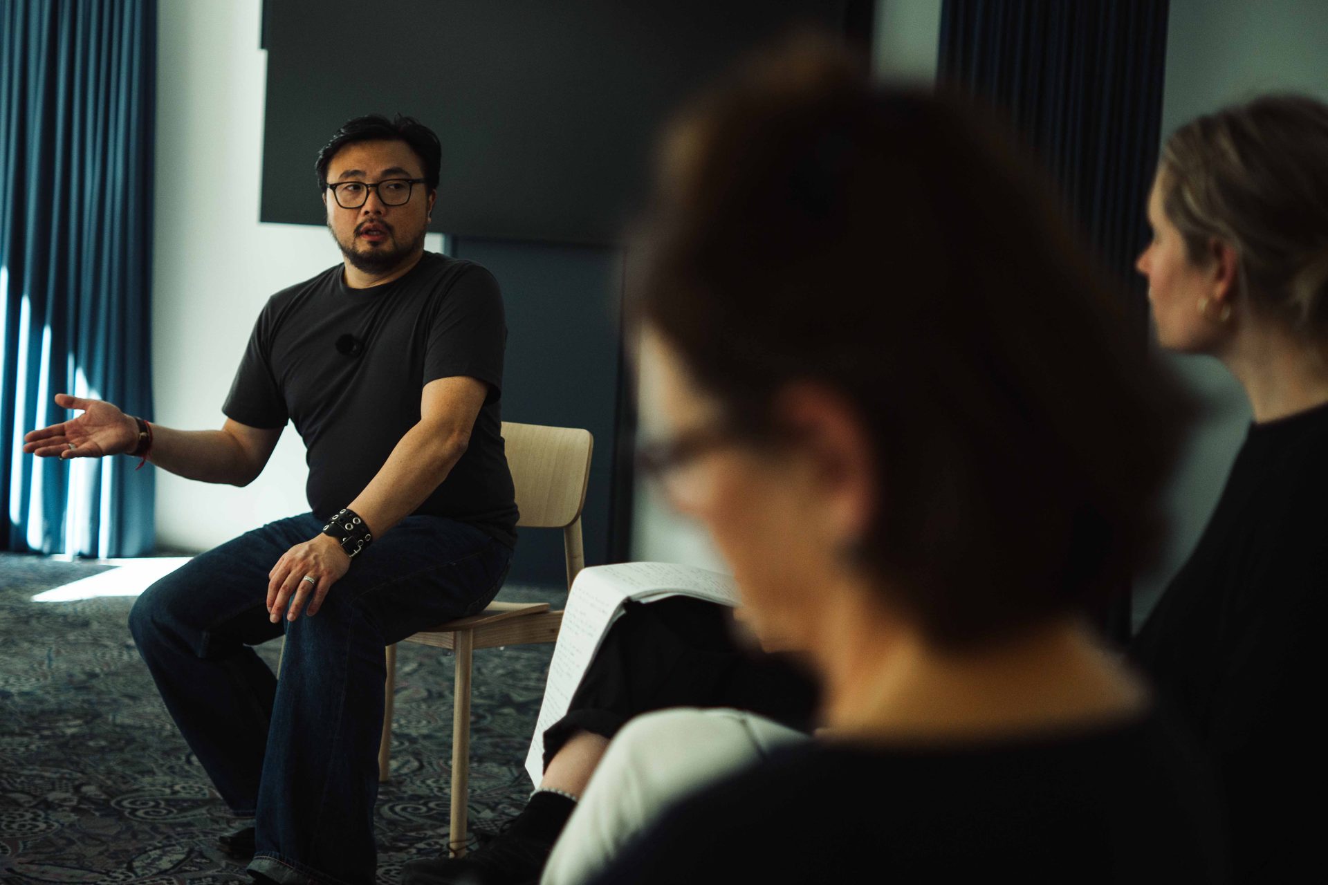 Christophe Tek directing a scene with a precise gesture, facing participants.